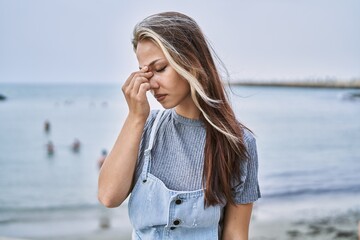 Young caucasian woman outdoors tired rubbing nose and eyes feeling fatigue and headache. stress and frustration concept.