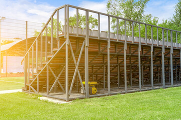 Yellow gasoline generator of electricity to provide energy for event stands under sports grandstand outdoors