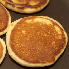 making thick pancakes on dark griddle surface