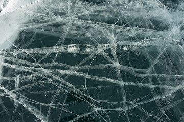 cracks in transparent ice in winter on the lake