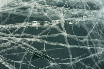 cracks in transparent ice in winter on the lake