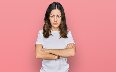 Fototapeta premium Young beautiful woman wearing casual white t shirt skeptic and nervous, disapproving expression on face with crossed arms. negative person.