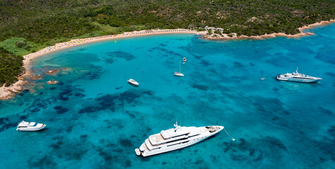View from above, stunning aerial view of a green coastline with a white sand beach and and boats...