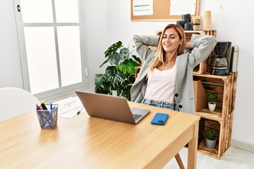 Young caucasian businesswoman relaxed with hands on head at the office.