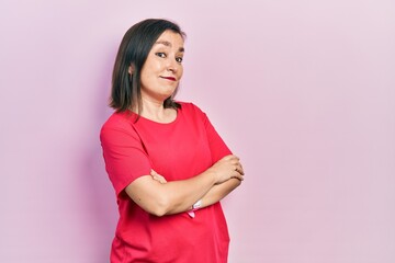 Middle age hispanic woman wearing casual clothes looking to the side with arms crossed convinced and confident