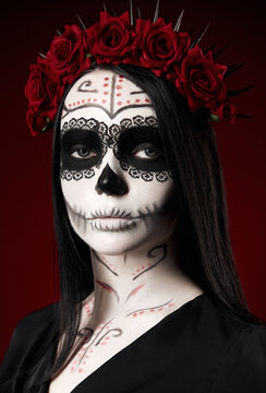 Young woman with calavera (sugar skull) makeup. The witch girl with muertos (muerte) greasepaint. Day of the dead (and Halloween) theme