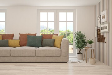 White living room with sofa and summer landscape in window. Scandinavian interior design. 3D illustration