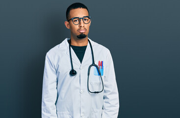 Fototapeta premium Young african american man wearing doctor uniform and stethoscope depressed and worry for distress, crying angry and afraid. sad expression.