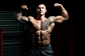 Fototapeta na wymiar Bodybuilder Performing Double Biceps Pose