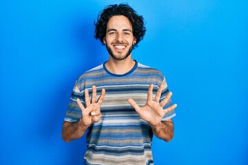 Handsome hispanic man wearing casual clothes over pink background showing and pointing up with...