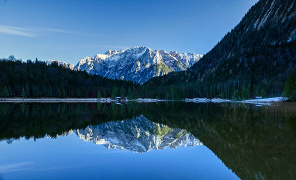 Alpiner Ferchensee mit verschneiter Bergpanorama Landschaft, die sich im Wasser und Waldhintergrund spiegelt