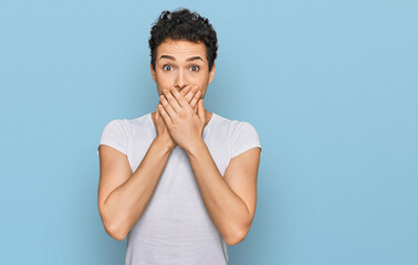 Young handsome man wearing casual white t shirt shocked covering mouth with hands for mistake. secret concept.