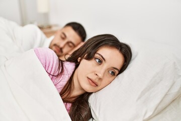 Fototapeta na wymiar Young hispanic couple sleeping on bed at home.