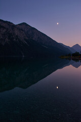 Moonrise above a beautiful mountain lake in the alps.