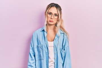 Beautiful young blonde woman wearing casual clothes and glasses depressed and worry for distress, crying angry and afraid. sad expression.