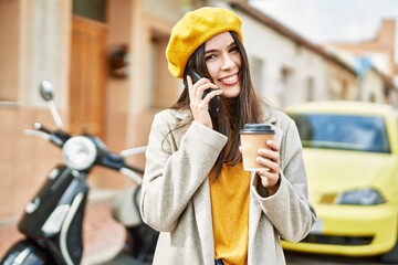 Young hispanic girl talking on the smartphone drinking coffee at the city.