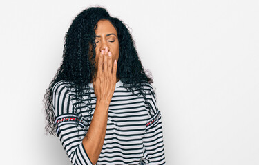 Middle age african american woman wearing casual clothes bored yawning tired covering mouth with hand. restless and sleepiness.