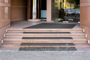 threshold with step with foot mat at entrance to store with tempered glass door in doorway tiled...