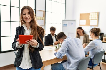 Young businesswoman smiling happy using touchpad while partners working at the office.
