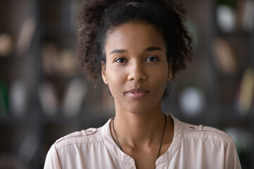 Close up headshot portrait of smiling young African American woman look at camera show leadership. Profile picture of millennial mixed race ethnicity female renter or tenant posing. Diversity concept.