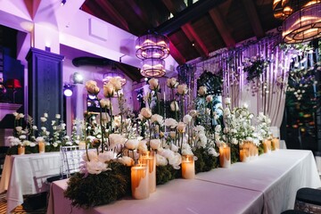 Romantic Wedding Table Top Layout Decor with large lush floral bouquets including white roses, ranunculus, persian buttercups, white orchids and candles