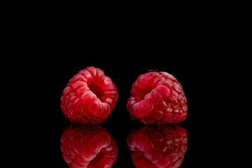 Two berries of ripe red raspberries, close-up, isolated on black.