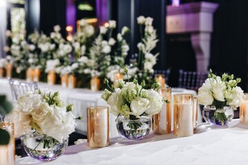 Romantic Wedding Table Top Layout Decor with large lush floral bouquets including white roses, ranunculus, persian buttercups, white orchids and candles