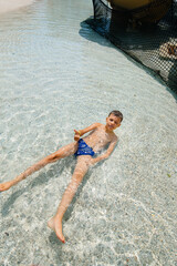 A happy boy of seven years old descends from the slides in the water park. Happy vacation vacation....