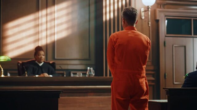 Court of Law and Justice Trial Proceedings: Law Offender in Orange Jumpsuit is Questioned and Giving Testimony to Judge, Jury. Criminal Denying Charges, Pleading, Inmate Denied Parole.