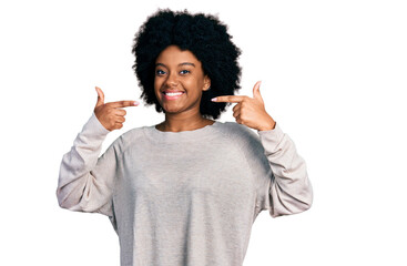 Young african american woman wearing casual clothes smiling cheerful showing and pointing with fingers teeth and mouth. dental health concept.