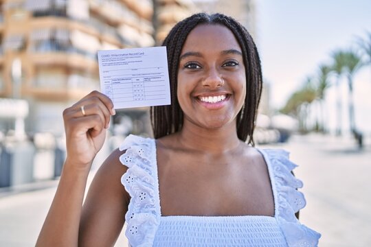 Young African American Girl Smiling Happy Holding Covid-19 Vaccination Record Card At The City.