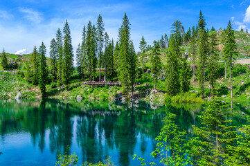 Paradise scenery at Karersee (Lago di Carezza, Carezza lake) in Dolomites of Italy at Mount Latemar, Bolzano province, South tyrol. Blue and crystal water. Travel destination of Europe.