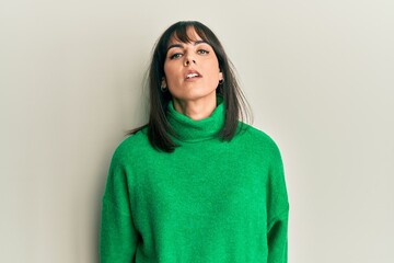 Fototapeta premium Young hispanic woman wearing casual winter sweater with serious expression on face. simple and natural looking at the camera.