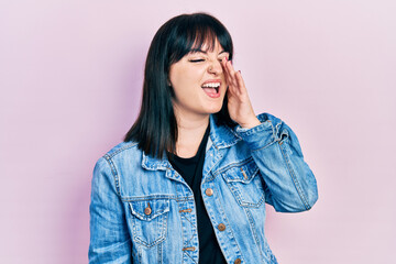 Young hispanic woman wearing casual clothes shouting and screaming loud to side with hand on mouth. communication concept.