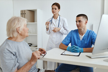 a doctor and a nurse examining an elderly woman patient