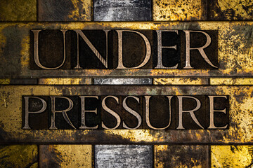 Under Pressure text message on textured grunge copper and vintage gold background