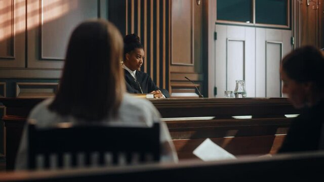 Court of Justice and Law Trial: Female Prosecutor Listening and Writing Down Notes to the Case Presented by Lawyer to Judge, Jury. Attorney Lawyer Protecting Client with Closing Supporting Argument.
