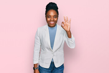 Young african american woman wearing business clothes smiling positive doing ok sign with hand and fingers. successful expression.