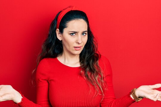 Young hispanic woman wearing casual clothes clueless and confused with open arms, no idea concept.