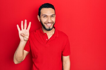 Fototapeta premium Hispanic man with beard wearing casual red t shirt showing and pointing up with fingers number four while smiling confident and happy.