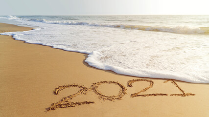 White waves are lapping towards shore, Goodbye 2021 hello to 2022 happy New Year coming concept.