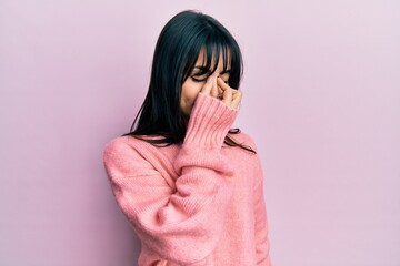 Young brunette woman with bangs wearing casual winter sweater tired rubbing nose and eyes feeling fatigue and headache. stress and frustration concept.