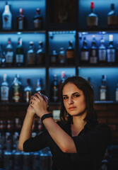 Portrait of young attractive woman bartender Making Cocktail Using Shaker in bar