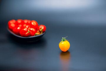 Discrimination Concept, Focused raw excluded tomato at foreground and defocused group of red...