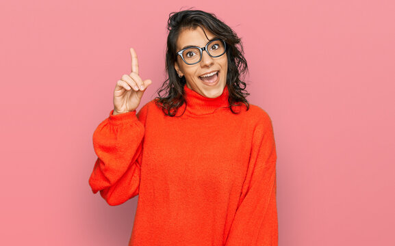 Young hispanic woman wearing casual clothes and glasses pointing finger up with successful idea. exited and happy. number one.
