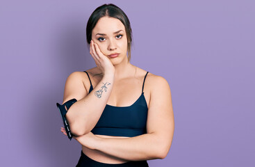 Young hispanic woman wearing sportswear thinking looking tired and bored with depression problems with crossed arms.