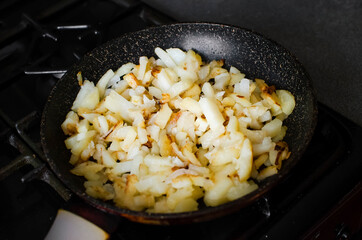 Roasted potatoes in iron skillet. Unhealthy food. Delicious dinner.