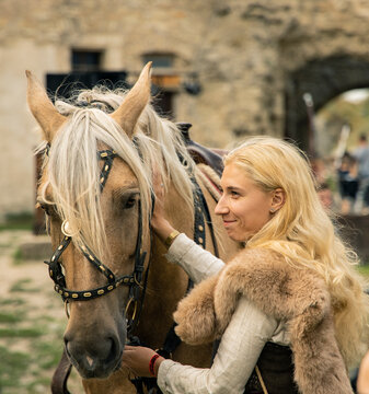 nordic Caucasian ethnicity woman with her horse dramatic cinematic photography in folk medieval style concept