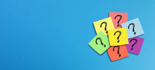 Note papers with question mark on panoramic blue background
