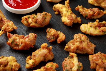 Chicken Pakora dish with sweet chilli sauce on rustic stone board